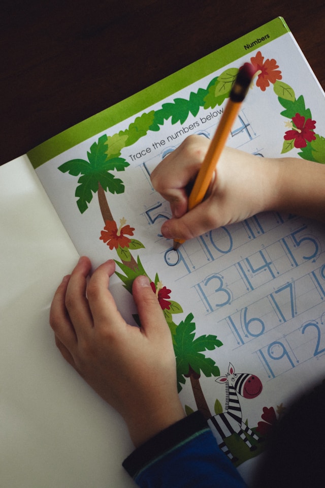 “Young child practising number writing as part of foundational maths skills at James An College Eastwood—an effective strategy for teaching times tables.”