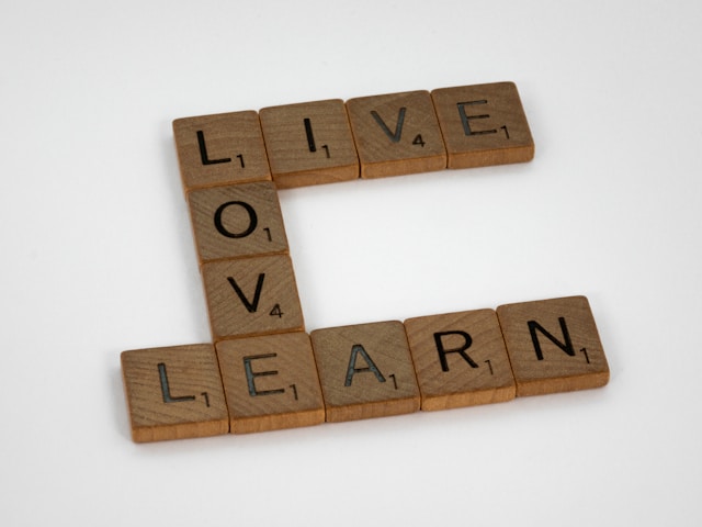 Wooden letter tiles arranged to spell “Live, Love, Learn,” symbolising the importance of connecting education to real-life values and experiences.