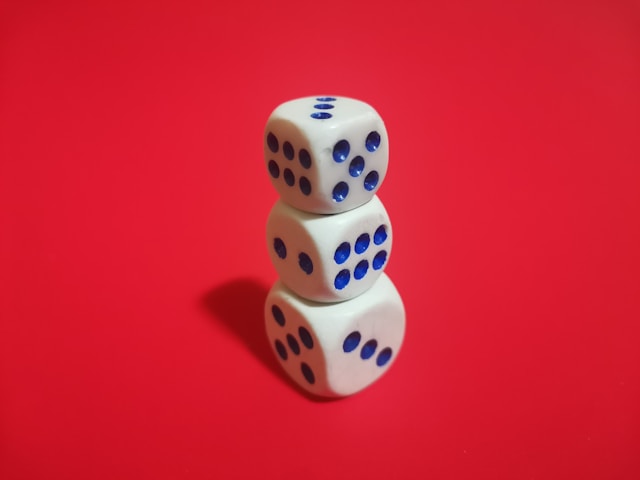 Stack of three dice on a red background representing playful, hands-on learning support cognitive development in children.