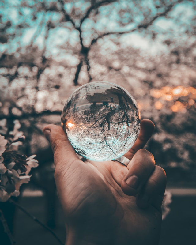 Child holding a crystal ball with trees reflected inside, symbolising the importance of reflection and identity in nurturing children's passions.