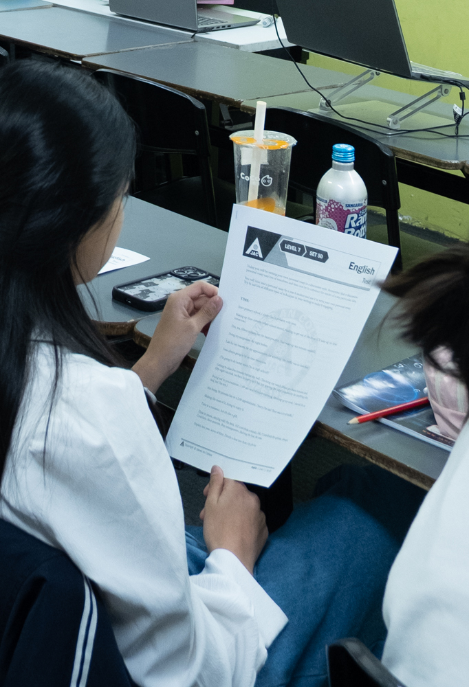 Teen student reviewing an English worksheet in a focused classroom setting, illustrating deep engagement and goal-setting as children develop their passions.